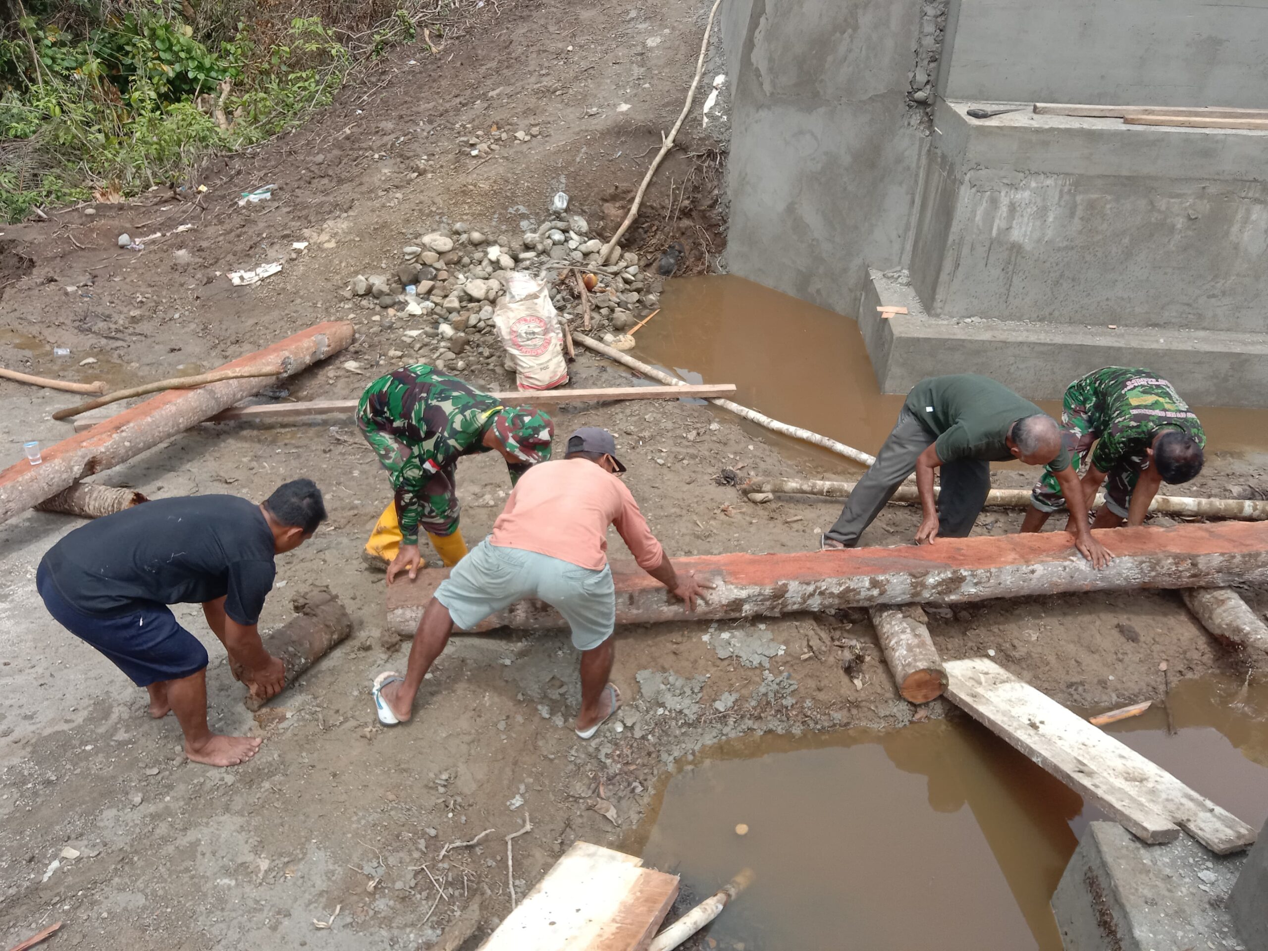 Anggota Kodim 1505/Tidore Bersama Warga Gotong Royong Angkat Batang Kelapa untuk Penahan Jembatan Garuda Anggota Kodim 1505/Tidore Bersama Warga Gotong Royong Angkat Batang Kelapa untuk Penahan Jembatan Garuda